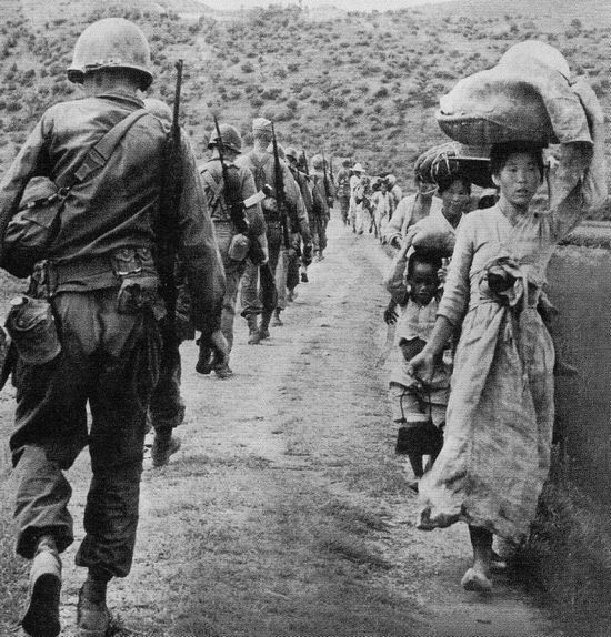 Lính Mỹ trên đường ra mặt trận gặp người dân chạy nạn, tháng 8 năm 1950. Ảnh: GEO EPOCHE
